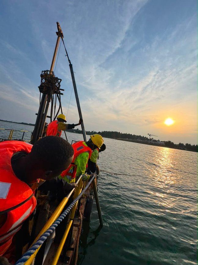 Tectoni over-water drilling platform silhouetted against a red sunset on Lake Victoria